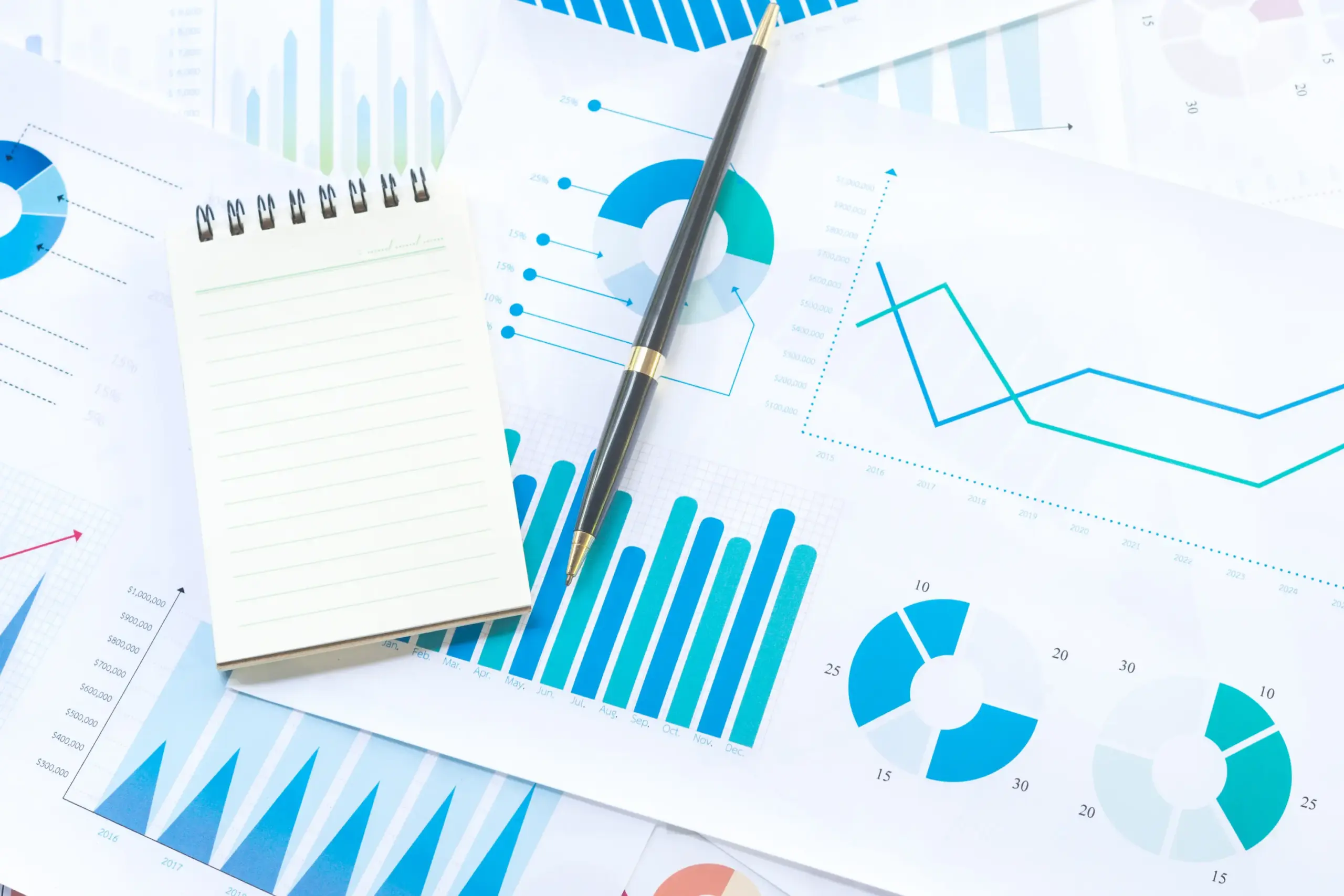 Financial charts and graphs with a notebook and pen on a desk